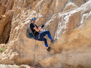 Kudüs, İsrail, 16 Nisan 2022: Deneyimli bir atlet, İsrail 'in Kudüs yakınlarındaki Tamarim deresi yakınlarındaki Musevi Çölü' nün dağlarında kırılma ekipmanlarıyla birlikte iniyor.