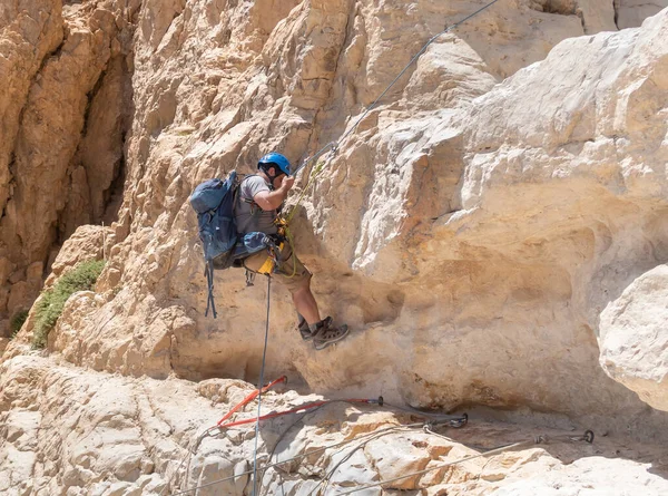 Kudüs, İsrail, 16 Nisan 2022: Deneyimli bir atlet, İsrail 'in Kudüs yakınlarındaki Tamarim deresi yakınlarındaki Musevi Çölü' nün dağlarında kırılma ekipmanlarıyla birlikte iniyor.