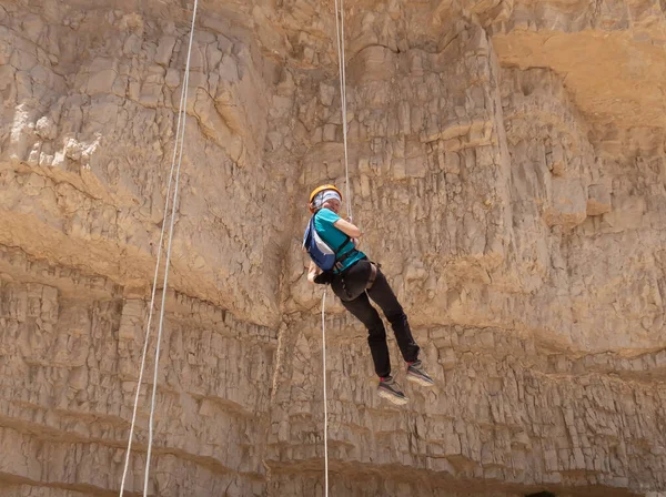 Kudüs, İsrail, 16 Nisan 2022: Deneyimli bir atlet, İsrail 'in Kudüs yakınlarındaki Tamarim deresi yakınlarındaki Musevi Çölü' nün dağlarında kırılma ekipmanlarıyla birlikte iniyor.