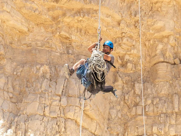 Kudüs, İsrail, 16 Nisan 2022: Deneyimli bir atlet, İsrail 'in Kudüs yakınlarındaki Tamarim deresi yakınlarındaki Musevi Çölü' nün dağlarında kırılma ekipmanlarıyla birlikte iniyor.