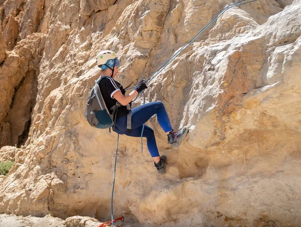 Kudüs, İsrail, 16 Nisan 2022: Deneyimli bir atlet, İsrail 'in Kudüs yakınlarındaki Tamarim deresi yakınlarındaki Musevi Çölü' nün dağlarında kırılma ekipmanlarıyla birlikte iniyor.