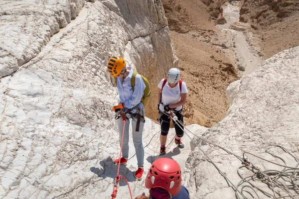 Kudüs, İsrail, 16 Nisan 2022: Deneyimli sporcular, İsrail 'in Kudüs yakınlarındaki Tamarim deresi yakınlarındaki Musevi Çölü' nün dağlarında kopan aletlerle inişe geçtiler.