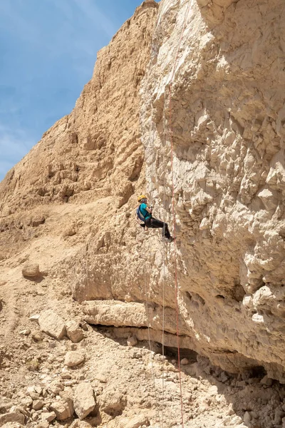 Kudüs, İsrail, 16 Nisan 2022: Deneyimli bir atlet, İsrail 'in Kudüs yakınlarındaki Tamarim deresi yakınlarındaki Musevi Çölü' nün dağlarında kırılma ekipmanlarıyla birlikte iniyor.