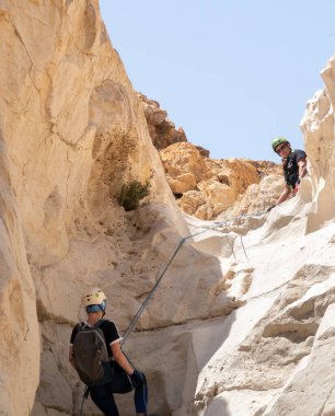 Kudüs, İsrail, 16 Nisan 2022: Deneyimli bir atlet, İsrail 'in Kudüs yakınlarındaki Tamarim deresi yakınlarındaki Musevi Çölü' nün dağlarında kırılma ekipmanlarıyla birlikte iniyor.
