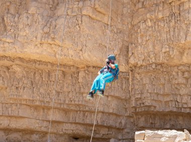 Kudüs, İsrail, 16 Nisan 2022: Deneyimli bir atlet, İsrail 'in Kudüs yakınlarındaki Tamarim deresi yakınlarındaki Musevi Çölü' nün dağlarında kırılma ekipmanlarıyla birlikte iniyor.
