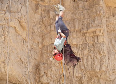 Kudüs, İsrail, 16 Nisan 2022: Tecrübeli bir atlet, İsrail 'in Kudüs yakınlarındaki Tamarim deresi yakınlarındaki Musevi Çölü' nün dağlarında kırılacak aletlerle baş aşağı iniyor.