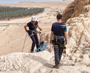 Kudüs, İsrail, 16 Nisan 2022: Tecrübeli bir atlet, İsrail 'in Kudüs yakınlarındaki Tamarim deresi yakınlarındaki Musevi Çölü' nün dağlarında kırılacak aletlerle baş aşağı iniyor.