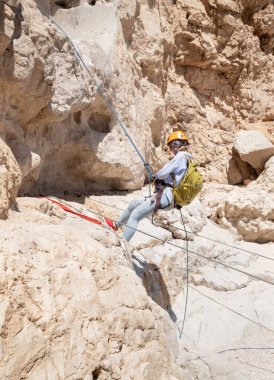 Kudüs, İsrail, 16 Nisan 2022: Deneyimli bir atlet, İsrail 'in Kudüs yakınlarındaki Tamarim deresi yakınlarındaki Musevi Çölü' nün dağlarında kırılma ekipmanlarıyla birlikte iniyor.