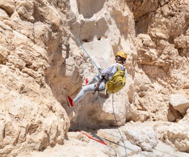 Kudüs, İsrail, 16 Nisan 2022: Deneyimli bir atlet, İsrail 'in Kudüs yakınlarındaki Tamarim deresi yakınlarındaki Musevi Çölü' nün dağlarında kırılma ekipmanlarıyla birlikte iniyor.