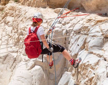 Kudüs, İsrail, 16 Nisan 2022: Deneyimli bir atlet, İsrail 'in Kudüs yakınlarındaki Tamarim deresi yakınlarındaki Musevi Çölü' nün dağlarında kırılma ekipmanlarıyla birlikte iniyor.