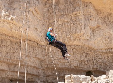 Kudüs, İsrail, 16 Nisan 2022: Deneyimli bir atlet, İsrail 'in Kudüs yakınlarındaki Tamarim deresi yakınlarındaki Musevi Çölü' nün dağlarında kırılma ekipmanlarıyla birlikte iniyor.