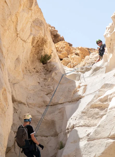 Kudüs, İsrail, 16 Nisan 2022: Deneyimli bir atlet, İsrail 'in Kudüs yakınlarındaki Tamarim deresi yakınlarındaki Musevi Çölü' nün dağlarında kırılma ekipmanlarıyla birlikte iniyor.