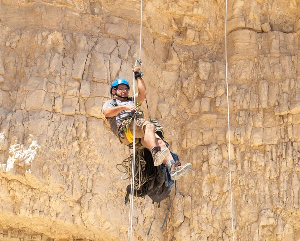 Kudüs, İsrail, 16 Nisan 2022: Deneyimli bir atlet, İsrail 'in Kudüs yakınlarındaki Tamarim deresi yakınlarındaki Musevi Çölü' nün dağlarında kırılma ekipmanlarıyla birlikte iniyor.