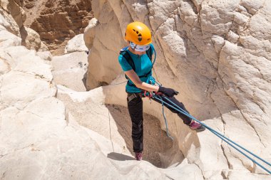 Kudüs, İsrail, 16 Nisan 2022: Deneyimli bir atlet, İsrail 'in Kudüs yakınlarındaki Tamarim deresi yakınlarındaki Musevi Çölü' nün dağlarında kırılma ekipmanlarıyla birlikte iniyor.