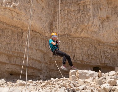 Kudüs, İsrail, 16 Nisan 2022: Deneyimli bir atlet, İsrail 'in Kudüs yakınlarındaki Tamarim deresi yakınlarındaki Musevi Çölü' nün dağlarında kırılma ekipmanlarıyla birlikte iniyor.