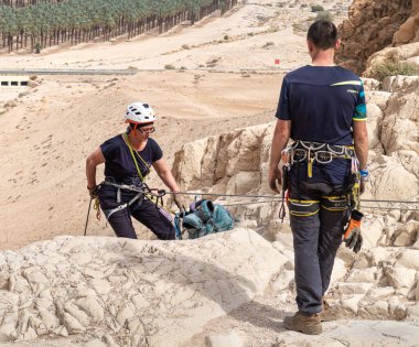 Kudüs, İsrail, 16 Nisan 2022: Tecrübeli bir atlet, İsrail 'in Kudüs yakınlarındaki Tamarim deresi yakınlarındaki Musevi Çölü' nün dağlarında kırılacak aletlerle baş aşağı iniyor.