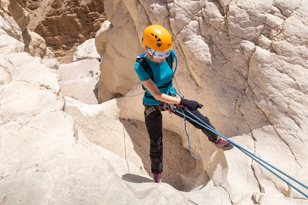 Kudüs, İsrail, 16 Nisan 2022: Deneyimli bir atlet, İsrail 'in Kudüs yakınlarındaki Tamarim deresi yakınlarındaki Musevi Çölü' nün dağlarında kırılma ekipmanlarıyla birlikte iniyor.