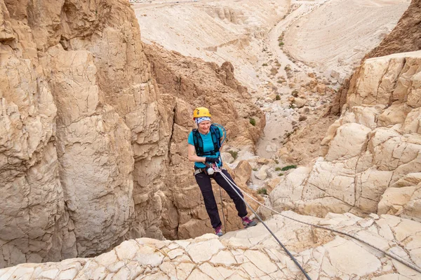 Kudüs, İsrail, 16 Nisan 2022: Tecrübeli bir atlet, İsrail 'in Kudüs yakınlarındaki Tamarim deresi yakınlarındaki Musevi Çölü' nün dağlarında kırılacak aletlerle baş aşağı iniyor.