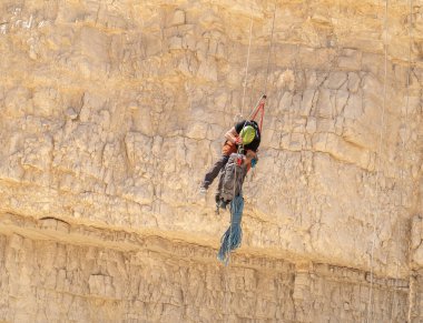 Kudüs, İsrail, 16 Nisan 2022: Deneyimli bir atlet, İsrail 'in Kudüs yakınlarındaki Tamarim deresi yakınlarındaki Musevi Çölü' nün dağlarında kırılma ekipmanlarıyla birlikte iniyor.