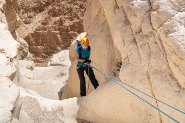 Kudüs, İsrail, 16 Nisan 2022: Deneyimli bir atlet, İsrail 'in Kudüs yakınlarındaki Tamarim deresi yakınlarındaki Musevi Çölü' nün dağlarında kırılma ekipmanlarıyla birlikte iniyor.