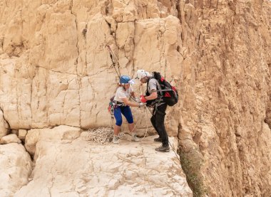Kudüs, İsrail, 05 Mayıs 2022: İsrail Bağımsızlık Günü 'ndeki ekstrem sporcular, İsrail' in Kudüs kenti yakınlarındaki Khatsatson deresi yakınlarındaki Judean Çölü dağlarında iple iple inmeye hazırlanıyorlar..