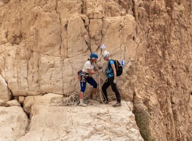 Kudüs, İsrail, 05 Mayıs 2022: İsrail Bağımsızlık Günü 'ndeki ekstrem sporcular, İsrail' in Kudüs kenti yakınlarındaki Khatsatson deresi yakınlarındaki Judean Çölü dağlarında iple iple inmeye hazırlanıyorlar..