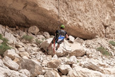 Kudüs, İsrail, 05 Mayıs 2022: İsrail Bağımsızlık Günü deneyimli sporcusu, İsrail 'in Kudüs kenti yakınlarındaki Khatsatson deresi yakınlarındaki Judean Çölü dağlarında iple iple iniyor..