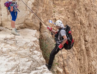 Kudüs, İsrail, 05 Mayıs 2022: İsrail Bağımsızlık Günü deneyimli sporcusu, İsrail 'in Kudüs kenti yakınlarındaki Khatsatson deresi yakınlarındaki Judean Çölü dağlarında iple iple inmeye başladı..