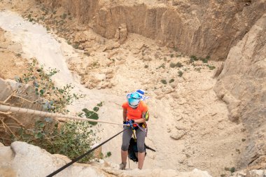 Kudüs, İsrail, 05 Mayıs 2022: İsrail Bağımsızlık Günü deneyimli sporcusu, İsrail 'in Kudüs kenti yakınlarındaki Khatsatson deresi yakınlarındaki Judean Çölü dağlarında iple iple iniyor..