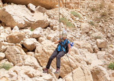 Kudüs, İsrail, 05 Mayıs 2022: İsrail Bağımsızlık Günü deneyimli sporcusu, İsrail 'in Kudüs kenti yakınlarındaki Khatsatson deresi yakınlarındaki Judean Çölü dağlarında iple iple inmeye başladı..