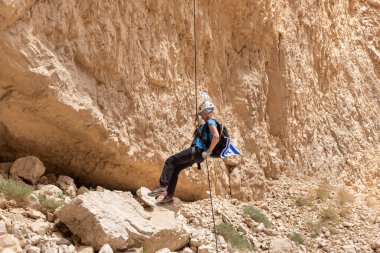 Kudüs, İsrail, 05 Mayıs 2022: İsrail Bağımsızlık Günü deneyimli sporcusu, İsrail 'in Kudüs kenti yakınlarındaki Khatsatson deresi yakınlarındaki Judean Çölü dağlarında iple iple iniyor..