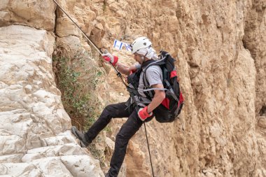 Kudüs, İsrail, 05 Mayıs 2022: İsrail Bağımsızlık Günü deneyimli sporcusu, İsrail 'in Kudüs kenti yakınlarındaki Khatsatson deresi yakınlarındaki Judean Çölü dağlarında iple iple inmeye başladı..