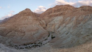 İsrail 'deki Kudüs yakınlarında, Ölü Deniz' in İsrail yakasındaki Khatsatson deresinin yakınındaki taştan çöl dağlarının şafağındaki görüntüsü