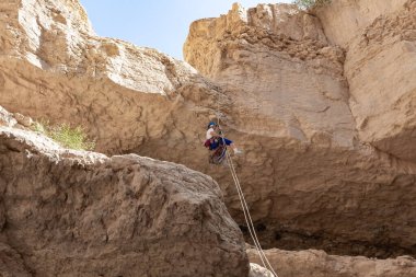 Kudüs, İsrail, 05 Mayıs 2022: İsrail Bağımsızlık Günü deneyimli sporcusu, İsrail 'in Kudüs kenti yakınlarındaki Khatsatson deresi yakınlarındaki Judean Çölü dağlarında iple iple iniyor..