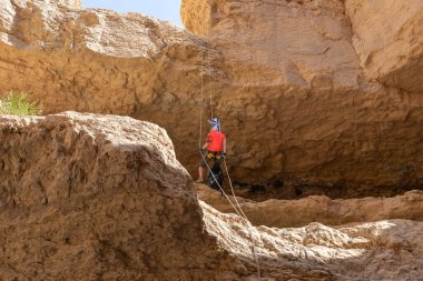 Kudüs, İsrail, 05 Mayıs 2022: İsrail Bağımsızlık Günü deneyimli sporcusu, İsrail 'in Kudüs kenti yakınlarındaki Khatsatson deresi yakınlarındaki Judean Çölü dağlarında iple iple iniyor..