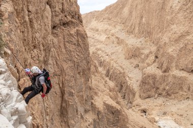 Kudüs, İsrail, 05 Mayıs 2022: İsrail Bağımsızlık Günü deneyimli sporcusu, İsrail 'in Kudüs kenti yakınlarındaki Khatsatson deresi yakınlarındaki Judean Çölü dağlarında iple iple inmeye başladı..