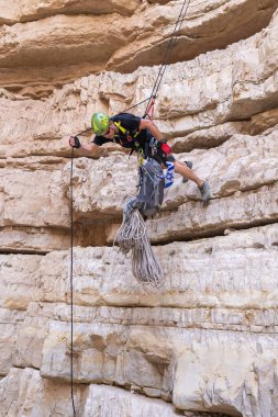 Kudüs, İsrail, 05 Mayıs 2022: İsrail Bağımsızlık Günü deneyimli sporcusu, İsrail 'in Kudüs kenti yakınlarındaki Khatsatson deresi yakınlarındaki Judean Çölü dağlarında iple iple iniyor..