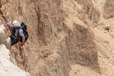 Kudüs, İsrail, 05 Mayıs 2022: İsrail Bağımsızlık Günü deneyimli sporcusu, İsrail 'in Kudüs kenti yakınlarındaki Khatsatson deresi yakınlarındaki Judean Çölü dağlarında iple iple inmeye başladı..