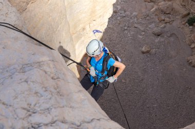 Kudüs, İsrail, 05 Mayıs 2022: İsrail Bağımsızlık Günü deneyimli sporcusu, İsrail 'in Kudüs kenti yakınlarındaki Khatsatson deresi yakınlarındaki Judean Çölü dağlarında iple iple iniyor..