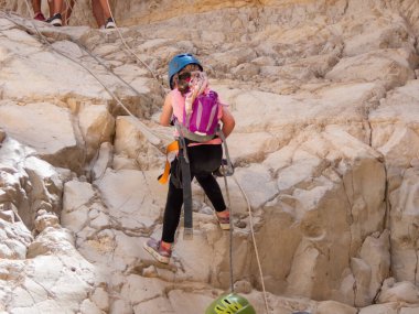 Kudüs, İsrail, Mayıs 05, 2022: Genç atlet İsrail 'in Kudüs kenti yakınlarındaki Rathe deresi yakınlarındaki Judean Çölü dağlarında ipe atlamak için ekipmanla iniyor.