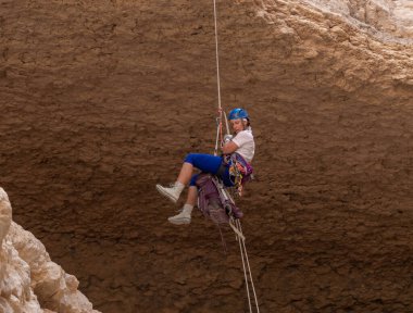 Kudüs, İsrail, 05 Mayıs 2022: İsrail Bağımsızlık Günü deneyimli sporcusu, İsrail 'in Kudüs kenti yakınlarındaki Khatsatson deresi yakınlarındaki Judean Çölü dağlarında iple iple iniyor..