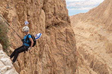 Kudüs, İsrail, 05 Mayıs 2022: İsrail Bağımsızlık Günü deneyimli sporcusu, İsrail 'in Kudüs kenti yakınlarındaki Khatsatson deresi yakınlarındaki Judean Çölü dağlarında iple iple inmeye başladı..