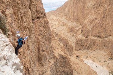 Kudüs, İsrail, 05 Mayıs 2022: İsrail Bağımsızlık Günü deneyimli sporcusu, İsrail 'in Kudüs kenti yakınlarındaki Khatsatson deresi yakınlarındaki Judean Çölü dağlarında iple iple inmeye başladı..