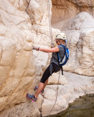 Kudüs, İsrail, Mayıs 05, 2022: İsrail 'in Kudüs kenti yakınlarındaki Rathe deresi yakınlarındaki Judean Çölü dağlarında iple iple iniş yapan deneyimli sporcu.