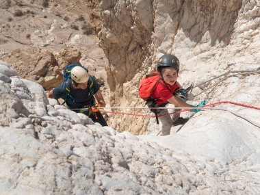 Kudüs, İsrail, 16 Nisan 2022: Sporcular, İsrail 'in Kudüs yakınlarındaki Tamarim deresi yakınlarındaki Musevi Çölü' nün dağlarında çatırdamak için ekipmanla dağdan inmeye başladılar.