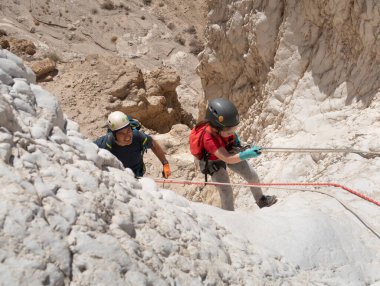 Kudüs, İsrail, 16 Nisan 2022: Sporcular, İsrail 'in Kudüs yakınlarındaki Tamarim deresi yakınlarındaki Musevi Çölü' nün dağlarında çatırdamak için ekipmanla dağdan inmeye başladılar.