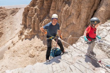 Kudüs, İsrail, 16 Nisan 2022: Sporcular, İsrail 'in Kudüs yakınlarındaki Tamarim deresi yakınlarındaki Musevi Çölü' nün dağlarında çatırdamak için ekipmanla dağdan inmeye başladılar.
