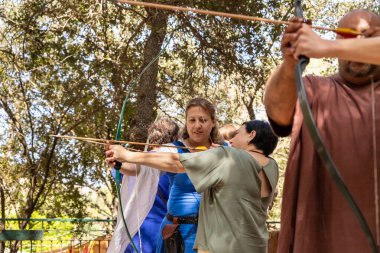 Kudüs, İsrail, 24 Eylül 2022: İsrail 'in Kudüs kentindeki Ein Yael Müzesi' nde düzenlenen festivale katılan bir katılımcının rehberliğinde okçuluk eğitimi alan bir ziyaretçi