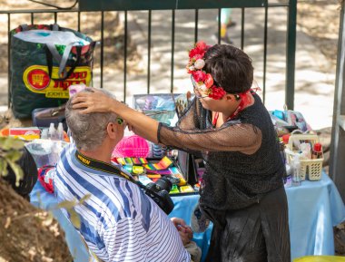 Kudüs, İsrail, 24 Eylül 2022: İsrail 'in Kudüs kentindeki Ein Yael Müzesi' nde düzenlenen Kudüs Şövalyeleri Festivali 'nde, bir sanatçı ziyaretçi yüzünde boya ve fırçayla resim yapar.