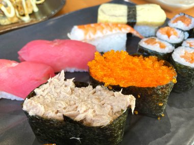 Assorted sushi nigiri and maki big set on slate. A variety of Japanese sushi with tuna, crab, salmon, eel and rolls.